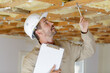 builder inspector looking at wooden ceiling struts