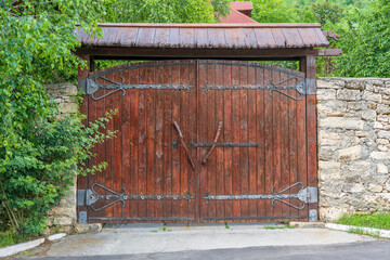 Wall Mural - Retro countryside wooden gate with with stone wall in vintage style, close up