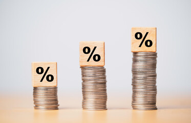 Percentage sign print screen on wooden cube block which lay down on increasing coins stacking for interest rate and business profit growth concept.