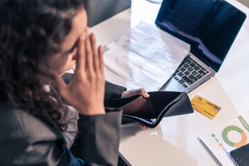 Wall Mural - Exhausted Latino business woman hurt eye while using laptop computer.