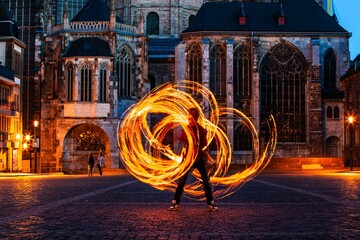 fire spinner creating shapes in front of cathedral