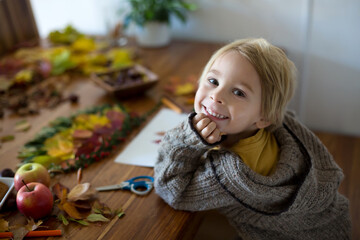 Wall Mural - Sweet child, boy, applying leaves using glue while doing arts and chraft with leaves