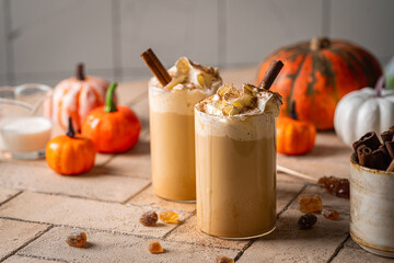 Autumn pumpkin spice latte with whipped cream and cinnamon on light background