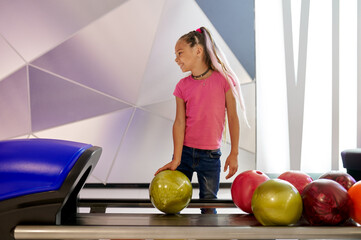 Wall Mural - Girl holds a ball at the lane in bowling alley