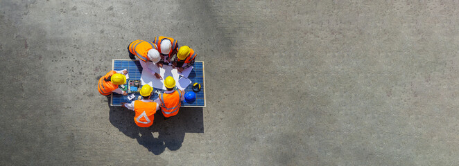 Top view of architectural engineer working on solar panel and his blueprints with Solar photovoltaic equipment on construction site. meeting, discussing, designing, planing, Clean energy concept