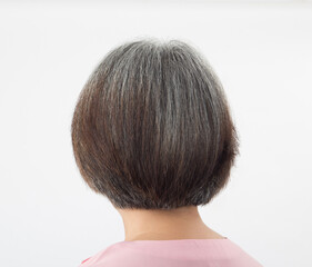 Head of elderly woman transforming to grey hair, from behind on white background