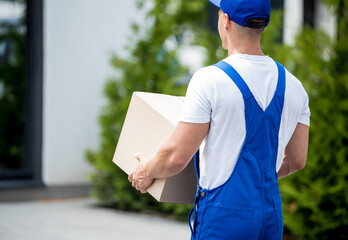 Young delivery man hold a cardboard box in his hands