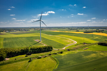 Wall Mural - Stunning wind turbine and field of rapeseed in countryside.