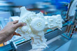 © xiaoliangge - man hand holding model of an internal combustion engine made of plastic on a 3d printer
