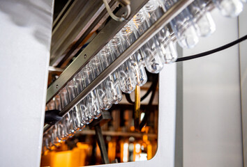 Wall Mural - Automatic filling machine pours water into plastic PET bottles at modern beverage plant.