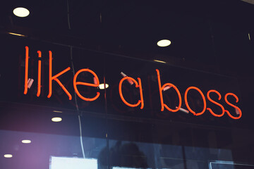 A view of a neon window sign that says Like A Boss.
