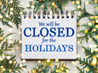 © Svetlana - Signboard with the inscription We will be closed for the holidays and green branches of a Christmas tree. View from above, closeup, indoors, no people. Congratulations for family, friends, colleagues