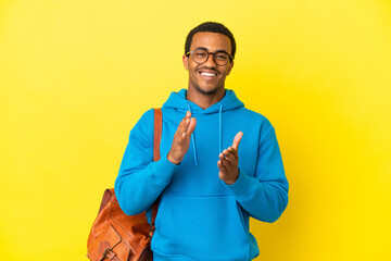 Wall Mural - African American student man over isolated yellow background applauding after presentation in a conference