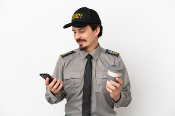 Wall Mural - Young caucasian security man isolated on white background holding coffee to take away and a mobile