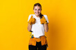© luismolinero - Young electrician woman isolated on yellow background with surprise facial expression