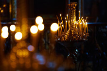 Religion And Magic. Candles Are Burning In A Dark Church. In The Background Is A Mysterious Dim Light And An Old Chandelier