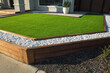 Artificial grass lawn turf with wooden edging in the front yard of a modern Australian home or residential house.