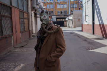 a woman walks down a gloomy street in a gas mask, mass infections and environmental problems, concept.