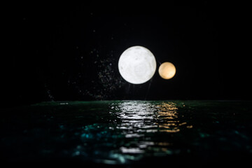 Wall Mural - Romantic and scenic panorama with full moon on sea to night. Table decoration with moon miniature and water.