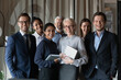 © fizkes - Human resource. Group portrait of smiling employees friendly team of diverse age race gender standing in office together. Successful motivated old young age multiethnic corporate staff look at camera