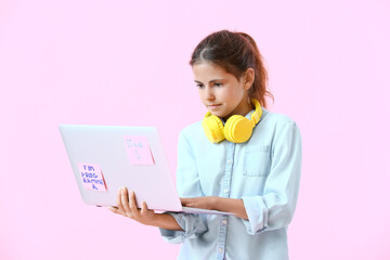 Little programmer using laptop on color background