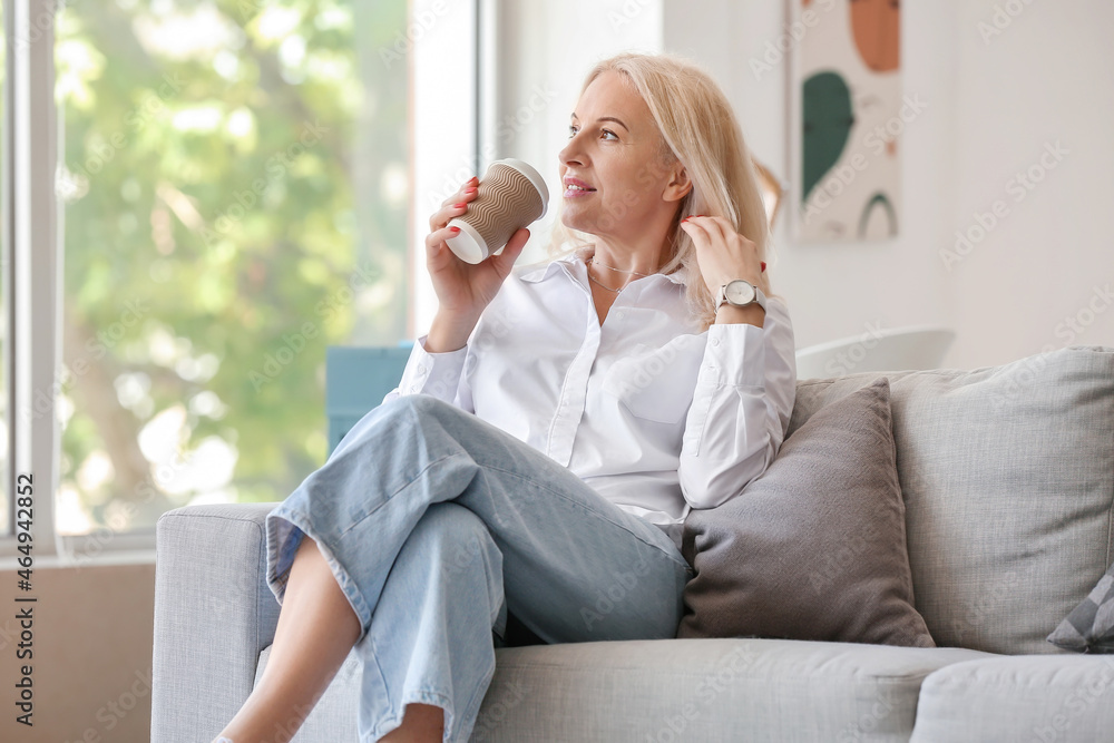 Mature woman drinking hot coffee at home