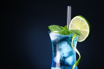 Glass of Blue Lagoon cocktail on dark background