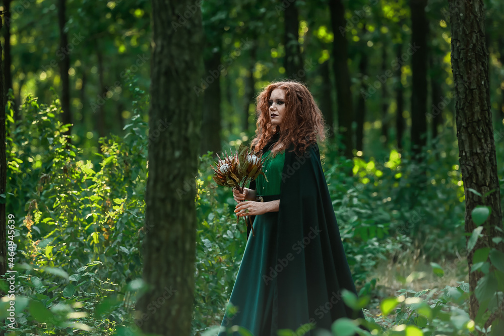 Young witch in green forest