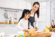 © Art_Photo - Portrait of enjoy happy love asian family mother and little toddler asian girl daughter child having fun cooking together with dough for homemade bake cookie and cake ingredient on table in kitchen