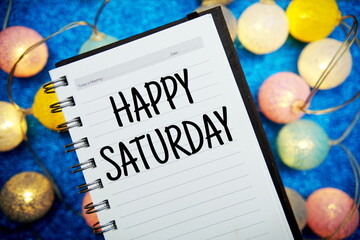 Wall Mural - happy saturday text notepad mockup and led cotton balls decoration on blue bokeh background