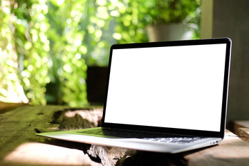 Wall Mural - Close up view computer laptop with empty screen on wooden table in the garden.