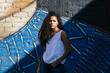 Portrait of a teenage Cuban girl outside in front of a mural with sunlight and, hispanic multiracial teenage woman