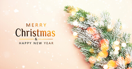 Wall Mural - Pink Christmas or New Year background with fir branches, pine cones and bokeh lights. with an .golden greeting text, top view