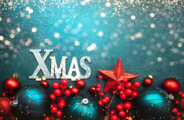 Wall Mural - Blue Christmas or New Year background with red and blue Christmas balls, berries, garland lights, golden bokeh and inscription Xmas, top view