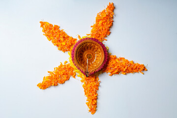 Wall Mural - Marigold Flower rangoli Design with oil lamps for Diwali Festival.