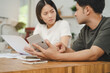 © KMPZZZ - Stressed, hand of asian young couple love family, confused by calculate expense from invoice or bill, have no money to pay. Mortgage, loan causing debt, bankruptcy. Debt problems, Financial people.