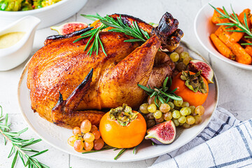 Wall Mural - Roasted whole chicken served with fruits on plate, baked Brussels sprouts and carrots. Christmas or Thanksgiving food concept.