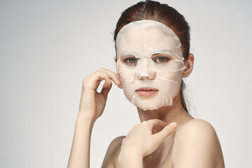 emotional woman cosmetic face mask close-up light background