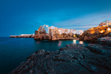 Wall Mural - Polignano a Mare at sunset (blue hour) seen from the panoramic point in front of the village