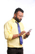 © Niks Ads - Young indian officer or student using smartphone on white background.