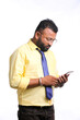 © Niks Ads - Young indian officer or student using smartphone on white background.