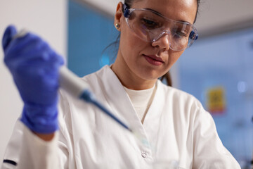 Wall Mural - closeup of scientist researcher doctor holding medical micropipette developing coronavirus vaccine d