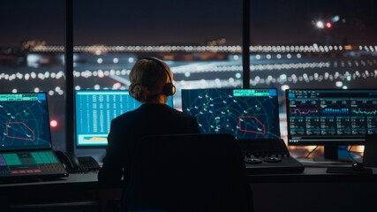 Wall Mural - Female Air Traffic Controller with Headset Talk on a Call in Airport Tower at Night. Office Room is Full of Desktop Computer Displays with Navigation Screens, Airplane Flight Radar Data for the Team.