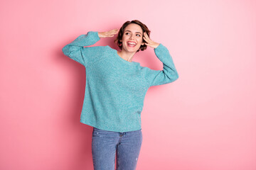 Poster - Photo of nice optimistic curly brunette hairdo lady look empty space wear blue sweater jeans isolated on pastel pink color background