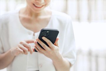 Happy woman hand holding mobile phone, she chatting online messaging and social network on mobile. copy space