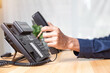© A Stockphoto - Call center staff man hand point to press the button number on the phone office desk , Communication support, call center and customer service help desk. for (call center) concept