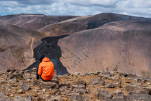 Anonymous Traveler Admiring Landscape Of Volcano Under Cloudy Sky