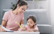 © Cheangchai - The daughter is doing homework together with her mother.
