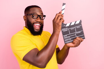 Wall Mural - Photo of happy trendy afro american cheerful brown haired man hold hands clapper isolated on pink color background