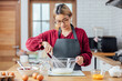 © vacancylizm - Beautiful young woman  is mixing batter, looking at camera and smiling while baking in kitchen at home ,decorating a cake of chocolate cake,cooking class, culinary, bakery, food and people concept